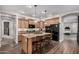 Modern kitchen featuring an island with seating, granite countertops, wood cabinets, and stainless steel appliances at 65 W Cucumber Tree Ave, San Tan Valley, AZ 85140