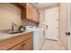 Clean laundry room featuring modern appliances, sink, cabinets and updated fixtures at 65 W Cucumber Tree Ave, San Tan Valley, AZ 85140