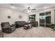 Comfortable living room with plush seating, neutral carpet, and sliding glass doors at 65 W Cucumber Tree Ave, San Tan Valley, AZ 85140