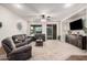 Inviting living room features neutral carpet, modern furniture, and ample natural light at 65 W Cucumber Tree Ave, San Tan Valley, AZ 85140