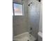 Bathroom with white tile surround, frosted window, and rainfall shower head at 6532 N 60Th N Ave, Glendale, AZ 85301