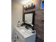 Stylish bathroom featuring a vanity with marble countertop, black fixtures, and wood accent wall at 6532 N 60Th N Ave, Glendale, AZ 85301