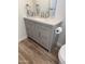 Modern bathroom vanity featuring gray cabinets, a white countertop, and brushed nickel fixtures at 6532 N 60Th N Ave, Glendale, AZ 85301