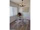 Bright dining room with modern lighting, glass-top table, and white chairs at 6532 N 60Th N Ave, Glendale, AZ 85301