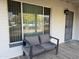 Inviting front porch with a gray tiled floor, comfortable cushioned seating, and secure metal gate at 6532 N 60Th N Ave, Glendale, AZ 85301