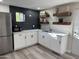 Modern kitchen with white cabinets, stainless steel appliances, and dark backsplash at 6532 N 60Th N Ave, Glendale, AZ 85301