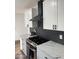 Contemporary kitchen with stainless steel stove, white cabinetry and black subway tile backsplash at 6532 N 60Th N Ave, Glendale, AZ 85301