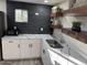 Modern kitchen featuring quartz countertops, stainless steel sink, and dark tile backsplash at 6532 N 60Th N Ave, Glendale, AZ 85301