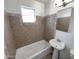 Cozy bathroom featuring a bathtub, window and a pedestal sink at 7020 E Oak St, Scottsdale, AZ 85257