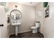 Cozy half bathroom with a pedestal sink, stylish mirror, and modern decor at 7456 E Milagro Ave, Mesa, AZ 85209