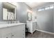 Bathroom featuring dual sink vanities, white cabinets, marble countertops, and modern fixtures at 7456 E Milagro Ave, Mesa, AZ 85209