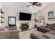 Comfortable living room features a ceiling fan, fireplace, and a large television at 7456 E Milagro Ave, Mesa, AZ 85209