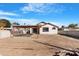 Spacious backyard with dirt and pavers, covered patio, block fence, and blue skies at 7510 N 59Th Ln, Glendale, AZ 85301