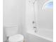 Clean white bathroom featuring a tub with shower, toilet, and half-moon window at 7510 N 59Th Ln, Glendale, AZ 85301