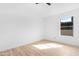 Bright bedroom with a large window, neutral color palette, and light-colored wood flooring at 7510 N 59Th Ln, Glendale, AZ 85301