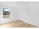 Bedroom with light wood flooring, white walls, window with view, and closet with sliding doors at 7510 N 59Th Ln, Glendale, AZ 85301