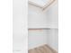 Bright, minimalist closet with wooden rails and neutral flooring, offering ample storage space at 7510 N 59Th Ln, Glendale, AZ 85301