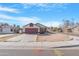 Charming single-story home features a red garage door and a well-maintained front yard, complemented by a clear blue sky at 7510 N 59Th Ln, Glendale, AZ 85301