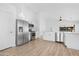 Modern kitchen features stainless steel appliances, white cabinetry, and a breakfast bar with sleek countertops at 7510 N 59Th Ln, Glendale, AZ 85301