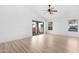 Bright living room with light wood floors, ceiling fan, and sliding glass doors to the backyard at 7510 N 59Th Ln, Glendale, AZ 85301