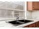 Well-lit kitchen sink area featuring granite counters, stainless steel faucet, and wooden cabinetry at 757 E Lovegrass Dr, San Tan Valley, AZ 85143