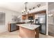 Well-lit kitchen featuring stainless steel appliances, granite counters, a central island, and wooden cabinetry at 757 E Lovegrass Dr, San Tan Valley, AZ 85143