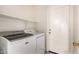 A modern laundry room features white front-loading washer and dryer at 757 E Lovegrass Dr, San Tan Valley, AZ 85143