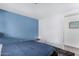 Simple bedroom with blue accent wall, queen bed, and small nightstand at 7645 E Gale Ave, Mesa, AZ 85209