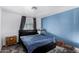 Simple bedroom features a blue accent wall, a queen-sized bed, and a gray rug at 7645 E Gale Ave, Mesa, AZ 85209