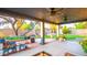 Covered patio showcasing a hammock, ceiling fans, wood shelves, potted plants, and backyard views at 824 W Luke Ave, Phoenix, AZ 85013