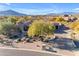 Stunning aerial view of a single-story home with desert landscaping, a two-car garage and mountain views at 8320 E Arroyo Hondo Rd, Scottsdale, AZ 85266