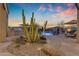 A backyard pool features water features, desert landscaping and lounge umbrellas at 8320 E Arroyo Hondo Rd, Scottsdale, AZ 85266