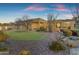 Expansive backyard with desert landscaping, a putting green, and a covered patio perfect for entertaining at 8320 E Arroyo Hondo Rd, Scottsdale, AZ 85266