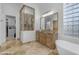 Beautiful bathroom with dual vanities, stand alone tub, travertine tile flooring, and glass enclosed shower at 8320 E Arroyo Hondo Rd, Scottsdale, AZ 85266