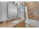 Bathroom featuring travertine tile surround, granite counters, and natural light at 8320 E Arroyo Hondo Rd, Scottsdale, AZ 85266