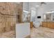 Large bright bathroom with a stand alone soaking tub, glass shower, and double vanity with wood cabinets at 8320 E Arroyo Hondo Rd, Scottsdale, AZ 85266