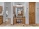 Bathroom vanity area featuring wood cabinets, granite counters, a makeup vanity, and decorative mirror at 8320 E Arroyo Hondo Rd, Scottsdale, AZ 85266