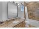 Well-lit bathroom features travertine tile, granite counters and a framed mirror at 8320 E Arroyo Hondo Rd, Scottsdale, AZ 85266