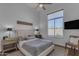 Bedroom featuring a tufted headboard, ceiling fan, and large window with natural lighting at 8320 E Arroyo Hondo Rd, Scottsdale, AZ 85266