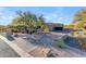 Single-story home featuring desert landscaping, a spacious driveway and a two-car garage at 8320 E Arroyo Hondo Rd, Scottsdale, AZ 85266