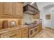 Modern kitchen features stainless steel range with custom range hood at 8320 E Arroyo Hondo Rd, Scottsdale, AZ 85266