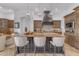 Kitchen island with marble countertops, stylish seating, and custom cabinetry at 8320 E Arroyo Hondo Rd, Scottsdale, AZ 85266