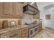 Professional-grade stainless steel range with custom backsplash and granite countertops at 8320 E Arroyo Hondo Rd, Scottsdale, AZ 85266