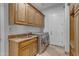 Laundry room featuring cabinets, sink and counter, plus newer stainless steel washer and dryer at 8320 E Arroyo Hondo Rd, Scottsdale, AZ 85266