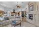 Cozy living room featuring a stone fireplace, plush seating, and a seamless connection to the kitchen at 8320 E Arroyo Hondo Rd, Scottsdale, AZ 85266