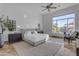 Main bedroom featuring neutral tones, a large window, and a ceiling fan at 8320 E Arroyo Hondo Rd, Scottsdale, AZ 85266