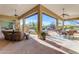 Inviting covered patio featuring comfortable seating, ceiling fans, and scenic views of the pool and landscaped desert landscape at 8320 E Arroyo Hondo Rd, Scottsdale, AZ 85266