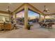 Luxurious patio featuring a seating area, dining space, outdoor kitchen, and picturesque sunset views over the pool at 8320 E Arroyo Hondo Rd, Scottsdale, AZ 85266