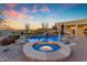 A backyard pool and spa includes water features, desert landscaping and lounge chairs at 8320 E Arroyo Hondo Rd, Scottsdale, AZ 85266