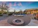 Gorgeous outdoor pool area with spa, waterfall feature, fire pit and desert landscaping at dusk at 8320 E Arroyo Hondo Rd, Scottsdale, AZ 85266